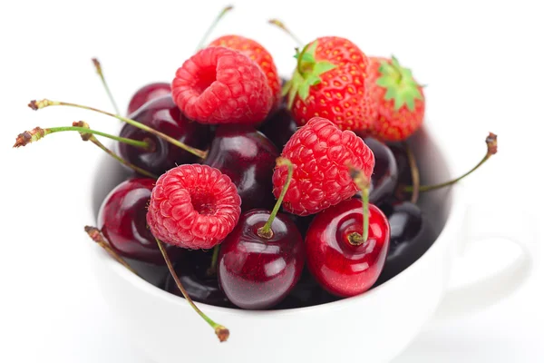 Bringebær, jordbær og kirsebær i en skål isolert på hvi – stockfoto