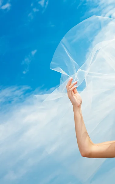Svatební šaty a závoj s rukou proti modré obloze — Stock fotografie