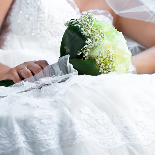 Bukett i händerna på bruden mot bakgrund av dres — Stockfoto