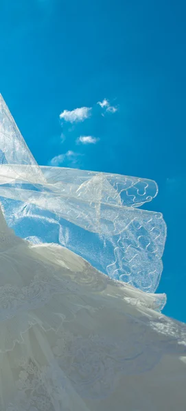 Bruiloft jurk en sluier tegen de blauwe hemel — Stockfoto