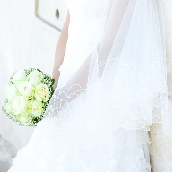 Bouquet entre les mains de la mariée sur fond de dres — Photo