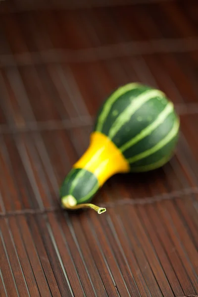 Gelb grüner Porzellan-Kürbis auf einer Bambusmatte — Stockfoto