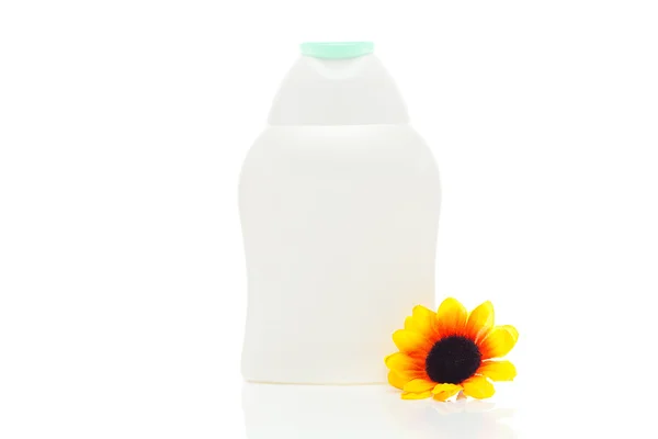 Envases de productos cosméticos y flor aislado en blanco — Stok fotoğraf