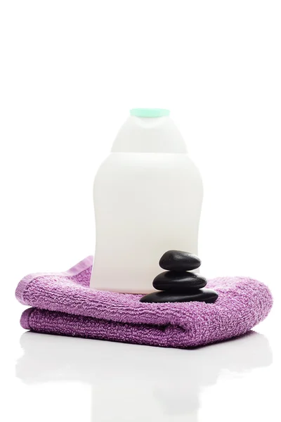 Recipientes cosméticos, toallas negras y piedras de spa aisladas en el blanco —  Fotos de Stock
