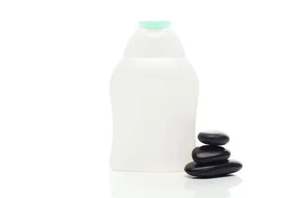 Kosmetikbehälter und Wellness schwarze Steine isoliert auf weiß — Stockfoto