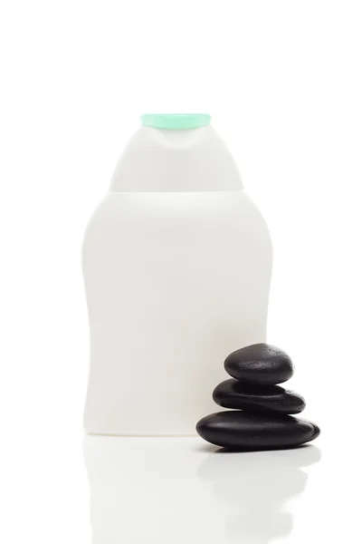 Kosmetikbehälter und Wellness schwarze Steine isoliert auf weiß — Stockfoto