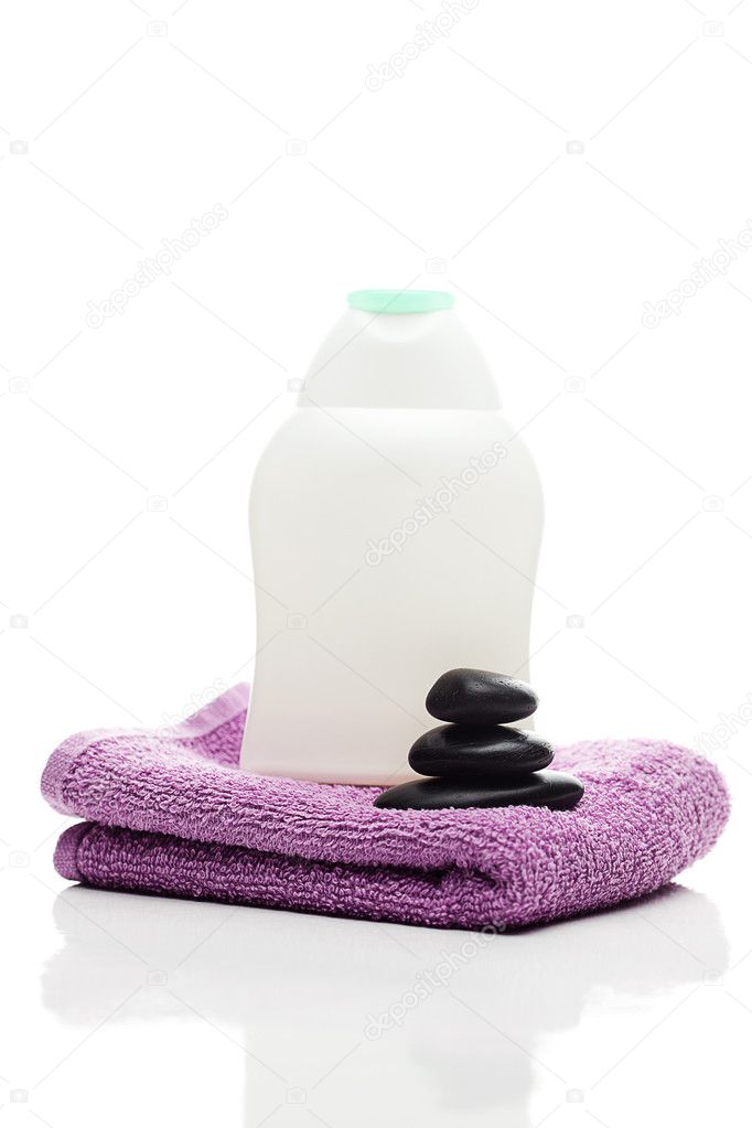 Cosmetic containers, black towel and spa stones isolated on whit