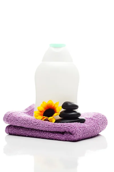 Recipientes cosméticos, flores, toallas y piedras de spa negras aisladas —  Fotos de Stock