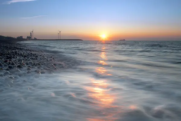 Reflexão do pôr do sol e do moinho de vento — Fotografia de Stock