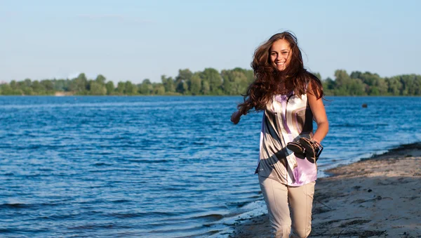 Jong meisje wordt uitgevoerd op de rivier bank — Stockfoto