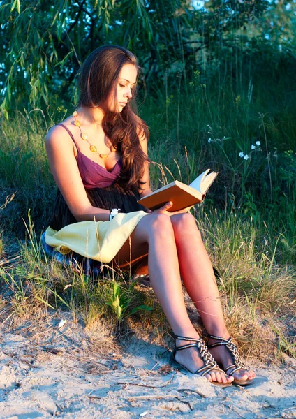 Młoda kobieta czytanie książki na zewnątrz — Zdjęcie stockowe