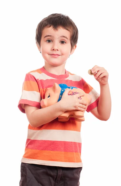 Litle boy puts the coin into the piggy bank — Stock Photo, Image