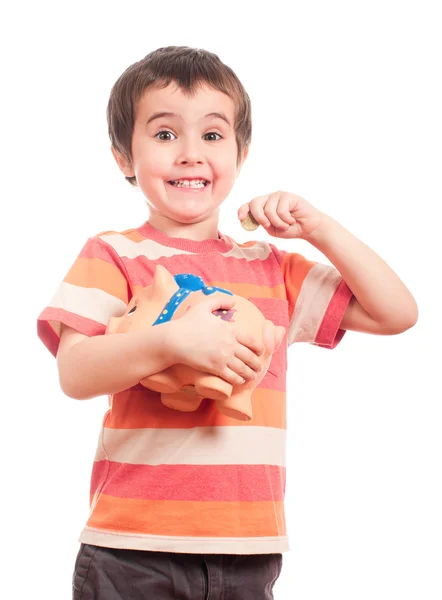 Drobná chlapec klade minci do prasátko — Stock fotografie