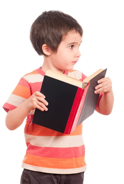 A kis fiú úgy néz ki, félre a könyv olvasása közben — Stock Fotó