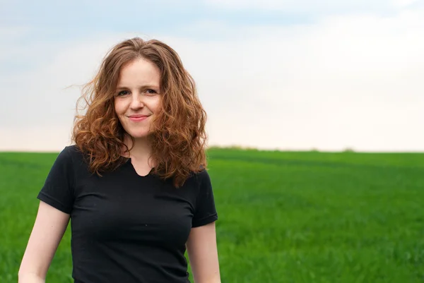 Mooie redhead vrouw op het groene veld — Stockfoto