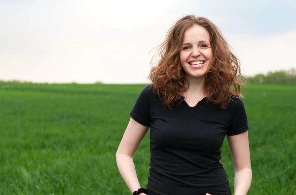 Счастливая девочка на открытом воздухе на зеленом поле — стоковое фото