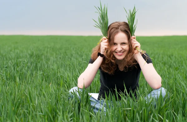 Rossa donna divertirsi sul campo verde — Foto Stock