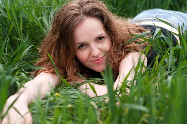 Piękna dziewczyna ukrywa się w zielonej trawie — Zdjęcie stockowe