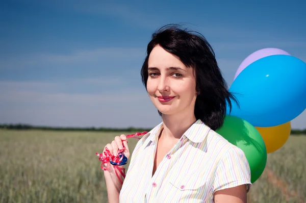 Mujer con globos de colores en el campo — Foto de Stock