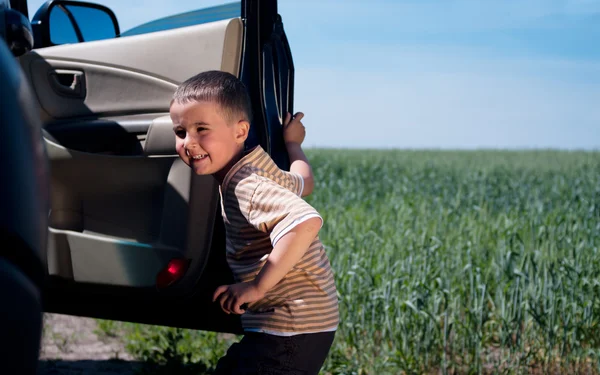 Malý chlapec opouští auto venku — Stock fotografie