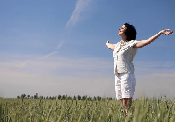 Счастливая женщина на пшеничном поле — стоковое фото