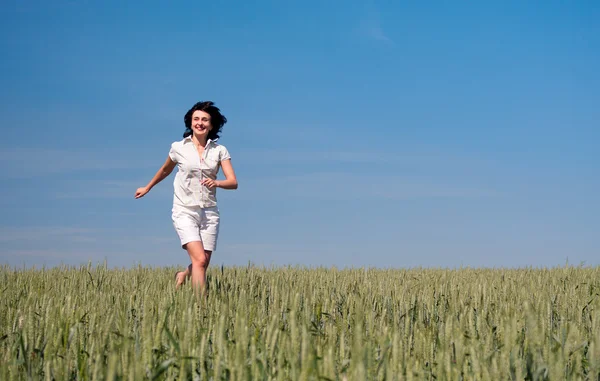 Woman running on the wheat field — Stock Photo, Image