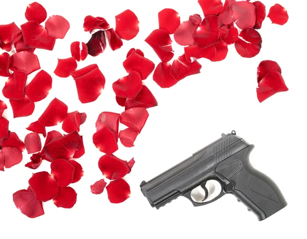 Pistola entre as petas rosa — Fotografia de Stock