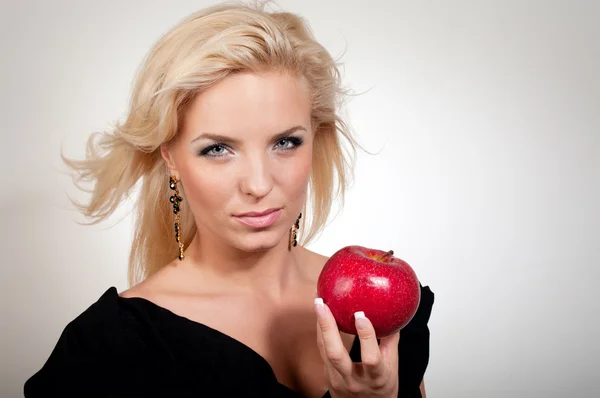 Blond kvinna anläggning rött äpple — Stockfoto