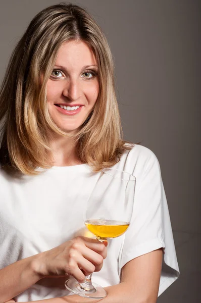 Frau schmeckt Weißwein und lächelt — Stockfoto