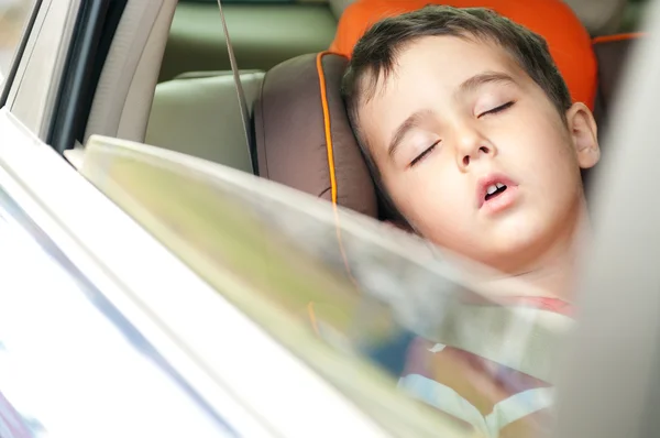 Litle boy sleeps in safe chair in car — Stock Photo, Image
