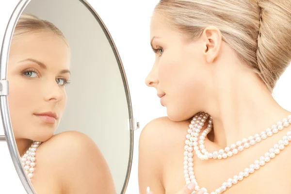 Bella donna con perline di perle e specchio — Foto Stock