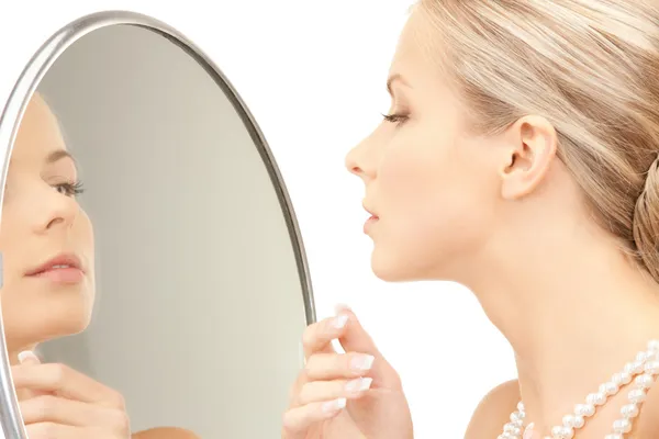 Vacker kvinna med pärlor och spegel — Stockfoto
