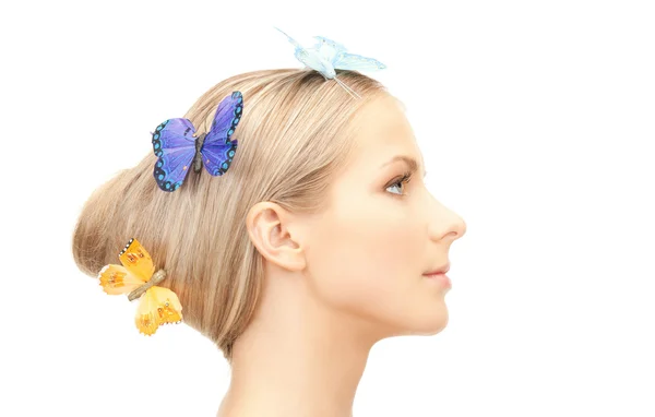 Красивая женщина с бабочкой в волосах — стоковое фото