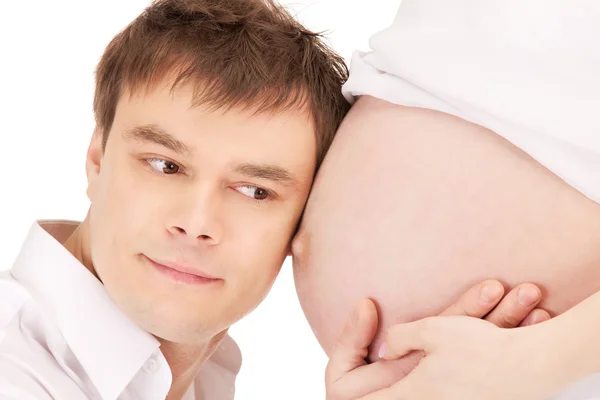 Manliga ansikte och gravid kvinna mage — Stockfoto