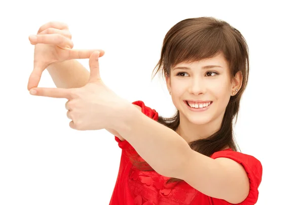 Genç kızın parmakları ile bir çerçeve oluşturma — Stok fotoğraf