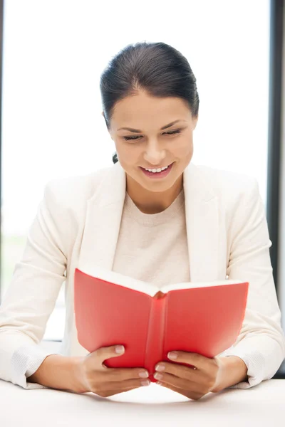 Šťastný a usmívající se žena s knihou — Stock fotografie