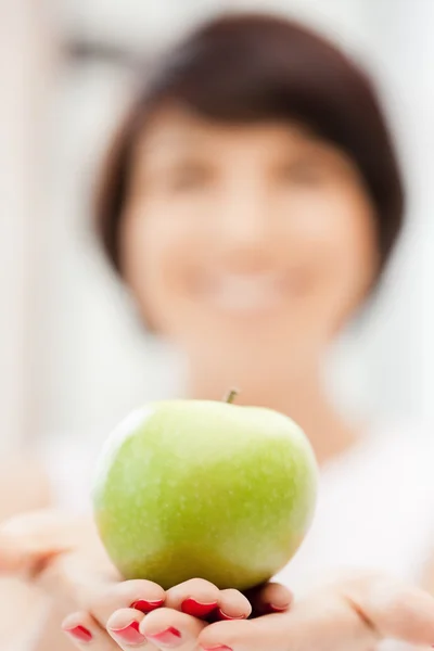 Schöne Hausfrau mit grünem Apfel lizenzfreie Stockfotos