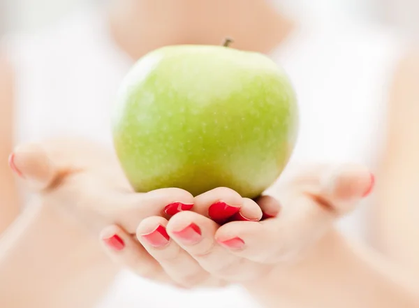Mãos femininas com maçã verde — Fotografia de Stock