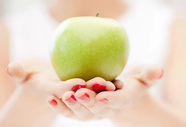 Kobiece ręce z zielonym jabłkiem — Zdjęcie stockowe
