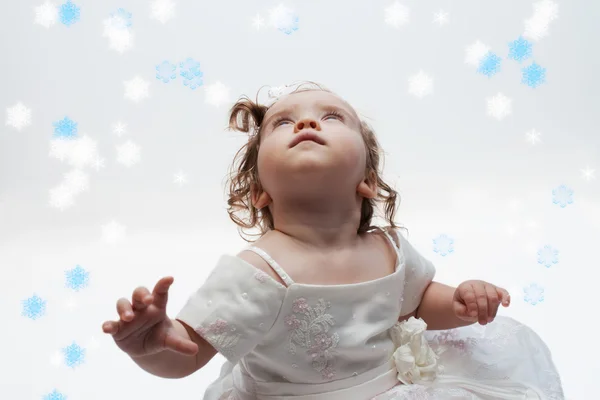 Kleines Mädchen schaut auf Schneeflocken — Stockfoto