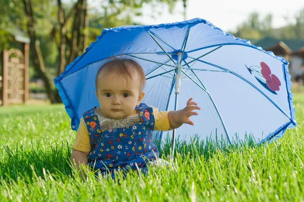 Baby sitzt unter Regenschirm — Stockfoto