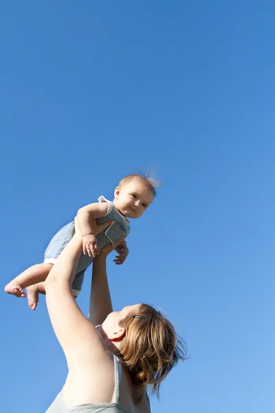 彼女の女の赤ちゃんを投げる母 — ストック写真