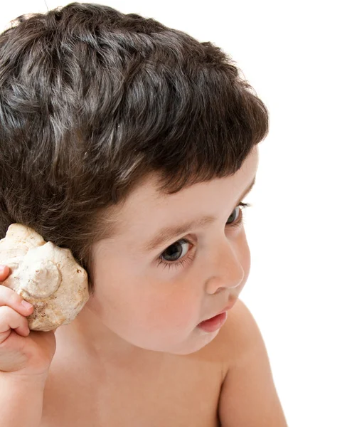 Liten pojke lyssna på seashell ljud, isolerade — Stockfoto