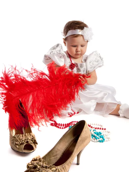 Маленька дівчинка тримає велике червоне перо, ізольоване — стокове фото
