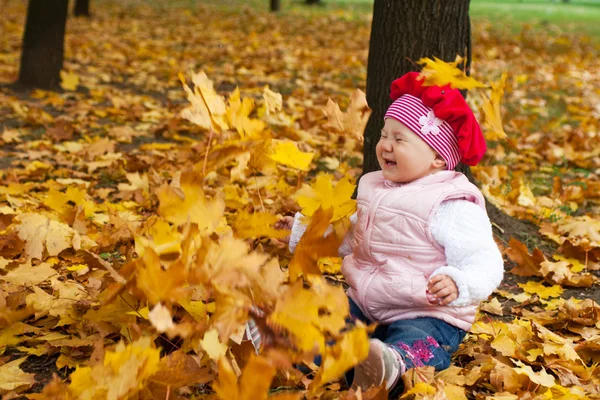 Смеющийся малыш и падающие листья — стоковое фото