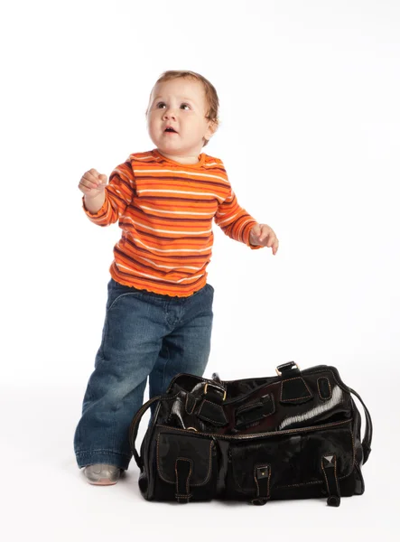 Kid står bredvid kvinnliga väska — Stockfoto