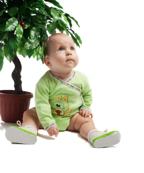 Dziecko siedzi pod zielonym drzewem — Zdjęcie stockowe