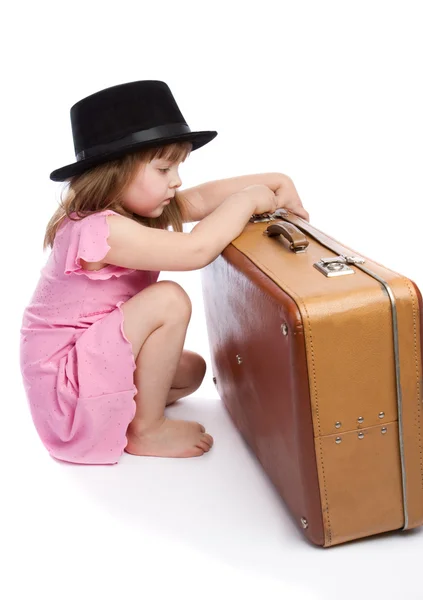 Menina tentando abrir uma mala — Fotografia de Stock