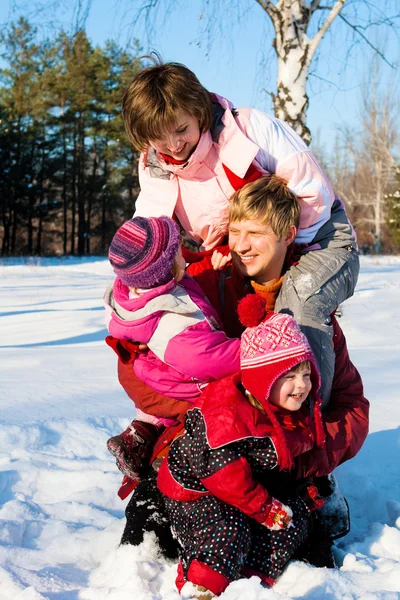Pais com filhas brincando na neve — Fotografia de Stock