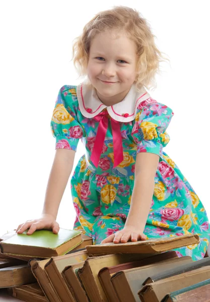 Dziewczyna siedzi wśród książek — Zdjęcie stockowe
